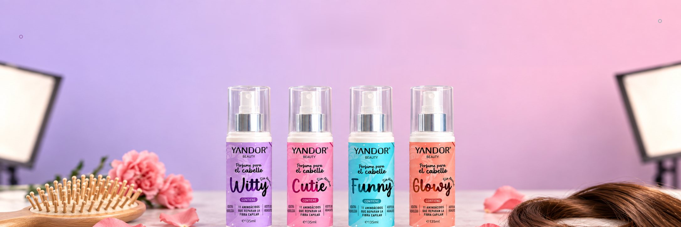 Los cuatro Perfumes para el Cabello Yandor: Witty, Cutie, Funny y Glowy, junto a un cepillo de madera, flores y un mechón de cabello